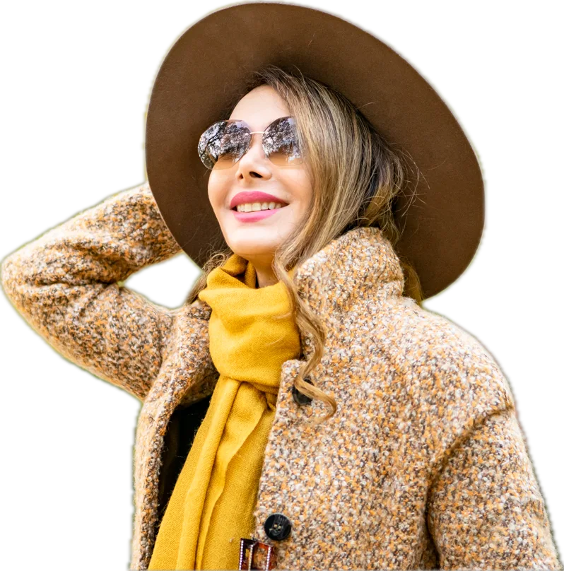 Shiva Boloorian smiling, in a wide-brimmed hat and mustard scarf