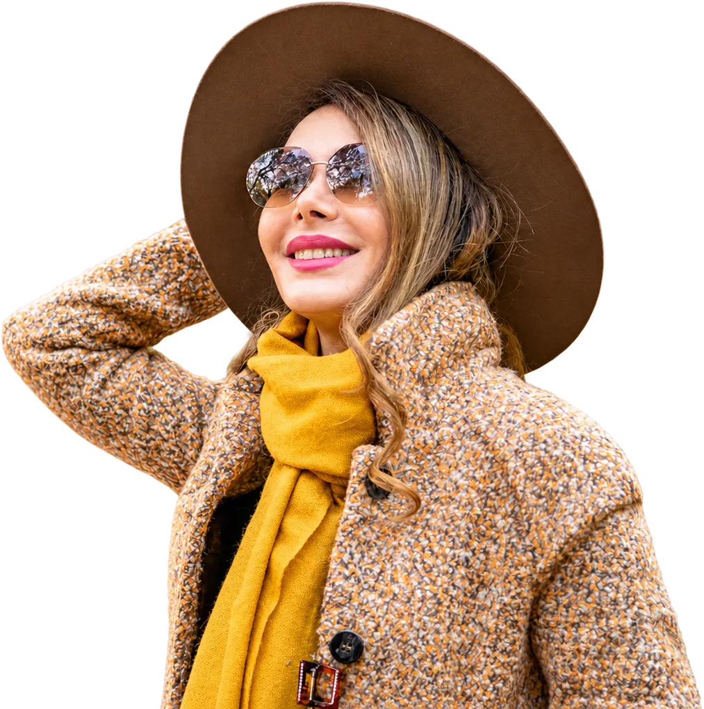 Shiva Boloorian smiling in a wide-brimmed hat, sunglasses and a mustard scarf